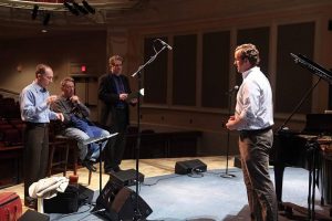 Philip Glass works with cast and staff on stage