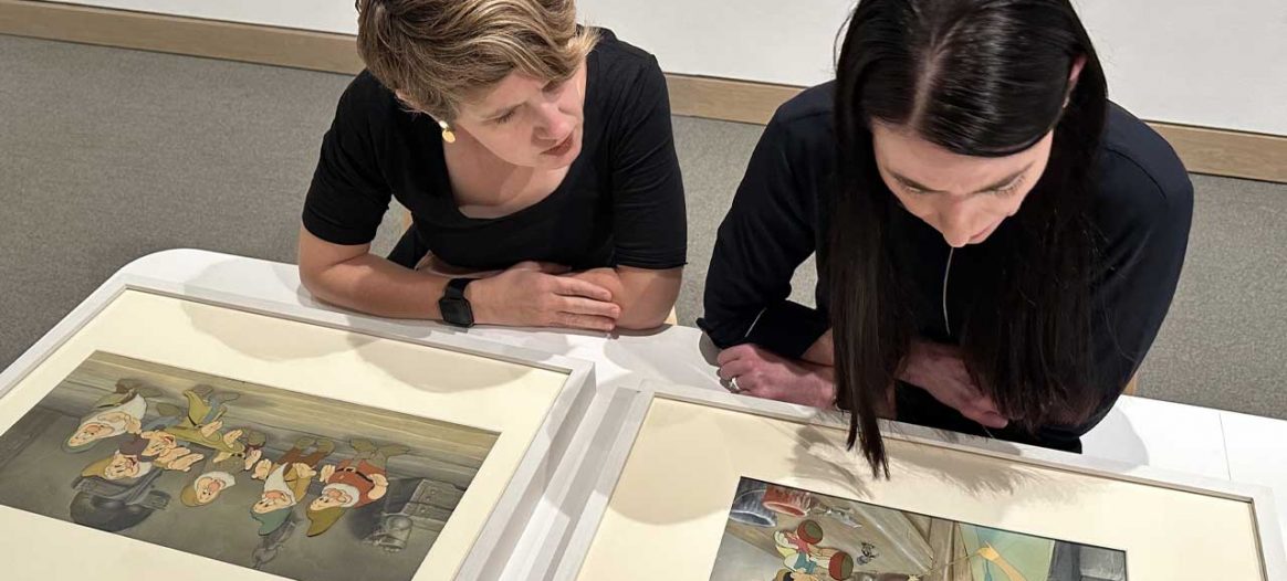 Curators Emily Stamey and Heather Holian looking at items in Golden Age of Disney exhibit