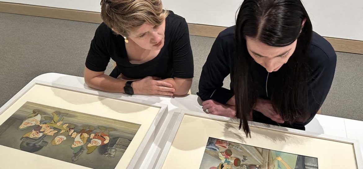 Curators Emily Stamey and Heather Holian looking at items in Golden Age of Disney exhibit