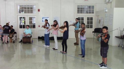 students performing on violins