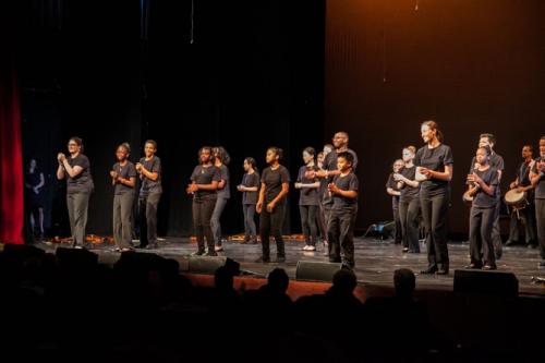 students performing onstage holding instruments