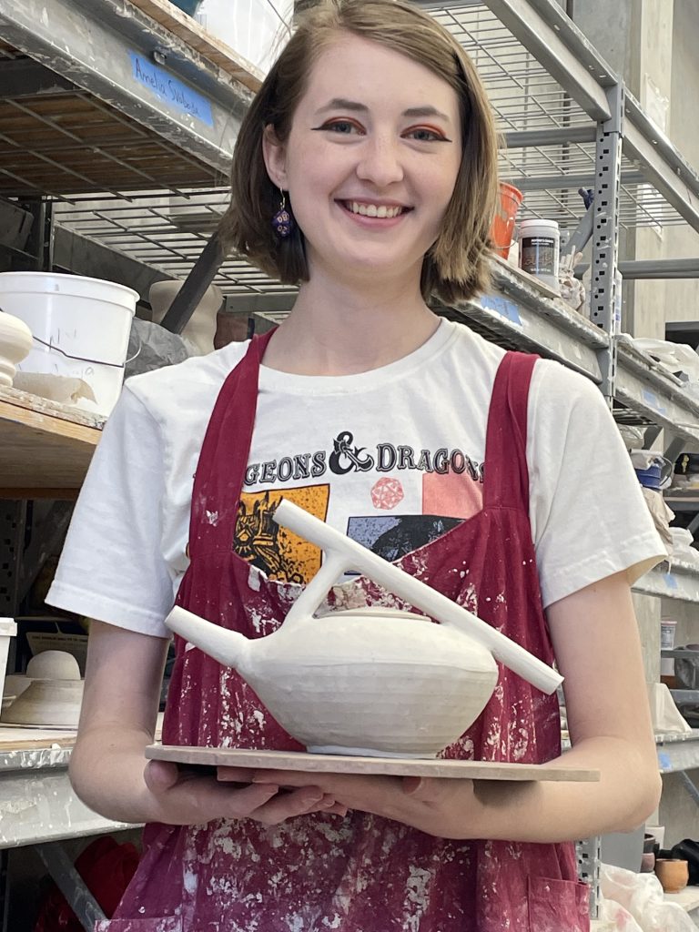 Meghan Fox '25 BFA Art Education with one of her ceramic works