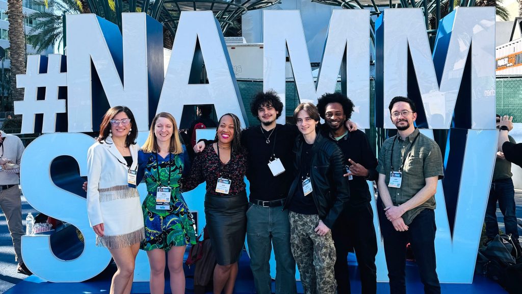 Group photo of students at National Association of Music Merchants (NAMM) sign