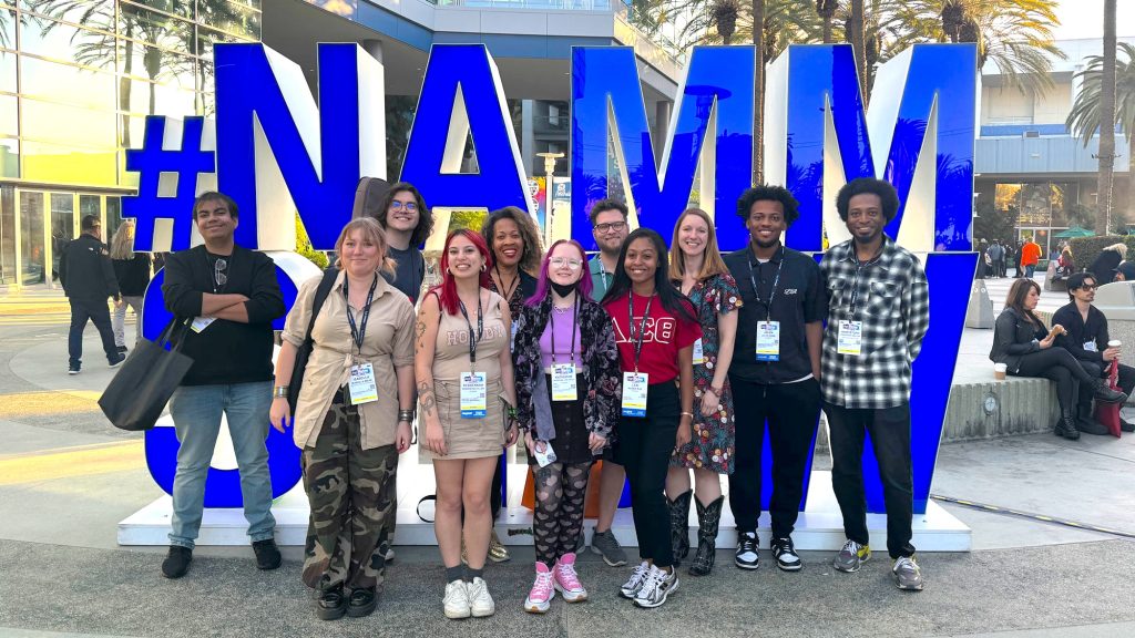 Group photo of students at National Association of Music Merchants (NAMM) sign